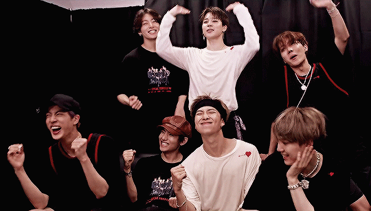 Gif of BTS looking content and smiling after a concert
